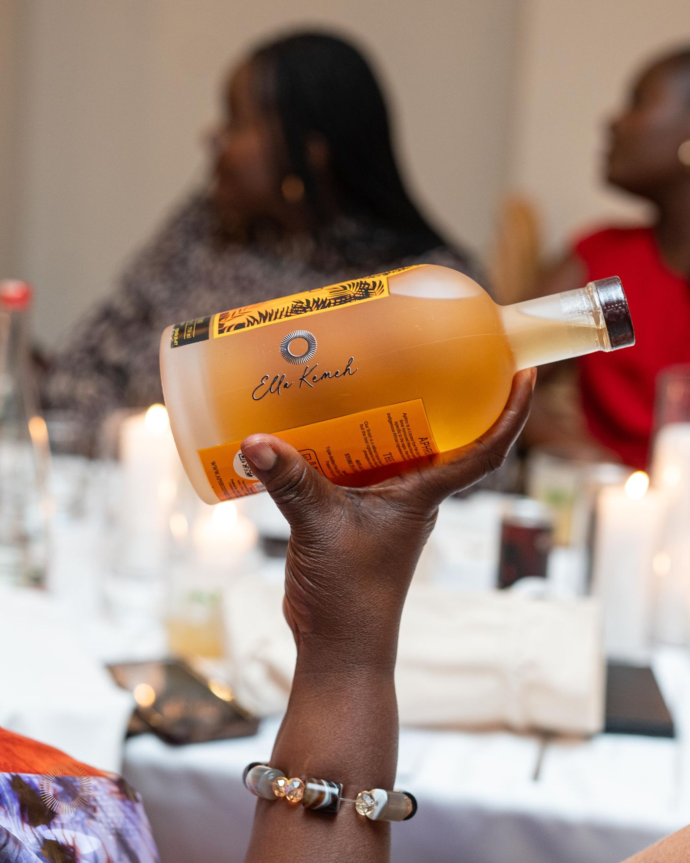 A guest raising a personalized Aphro bottle at a dinner event