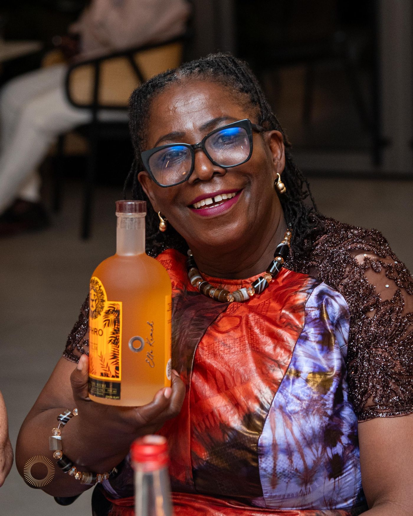 A guest smiling while holding her personalized bottle of Aphro